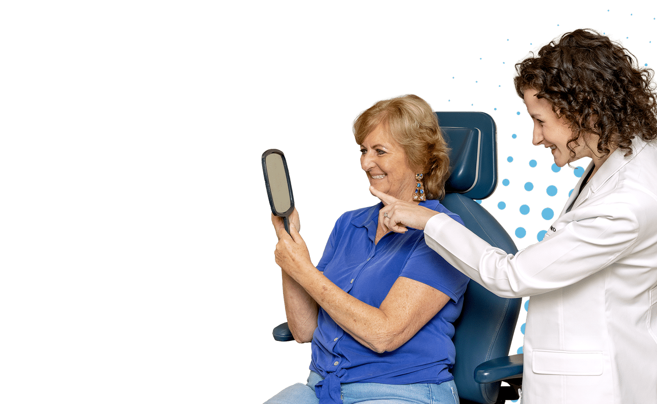 Two people in a medical setting, one holding a mirror. They appear engaged in a discussion or examination, with a dotted pattern background.
